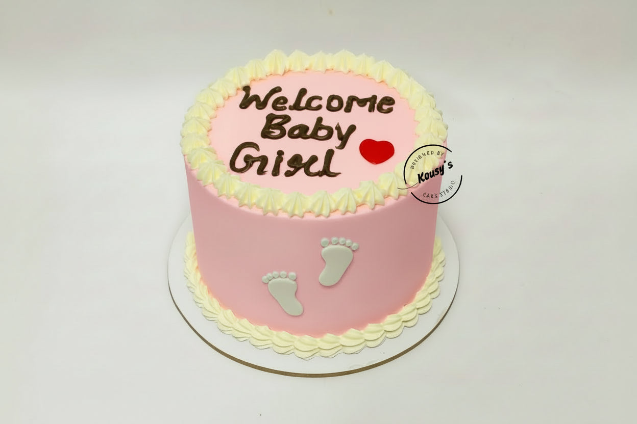 Pink baby shower cake with 'Welcome Baby Girl' text and footprints on a white background